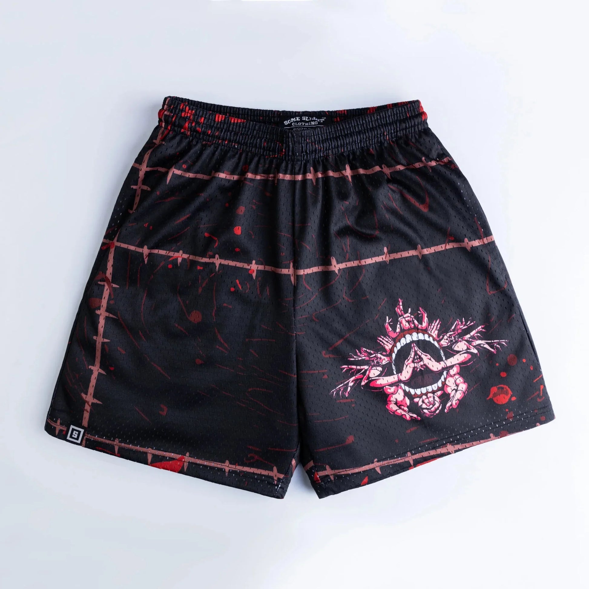 Black shorts with elastic waistband, red grid splatter design, and side logo tag