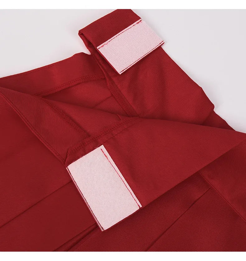 Détail tissu : ceinture et nœud de la jupe rouge, coutures internes et étiquette blanche.