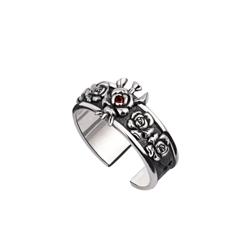 Bague argentée à décor floral, avec pierre rouge grenat sertie