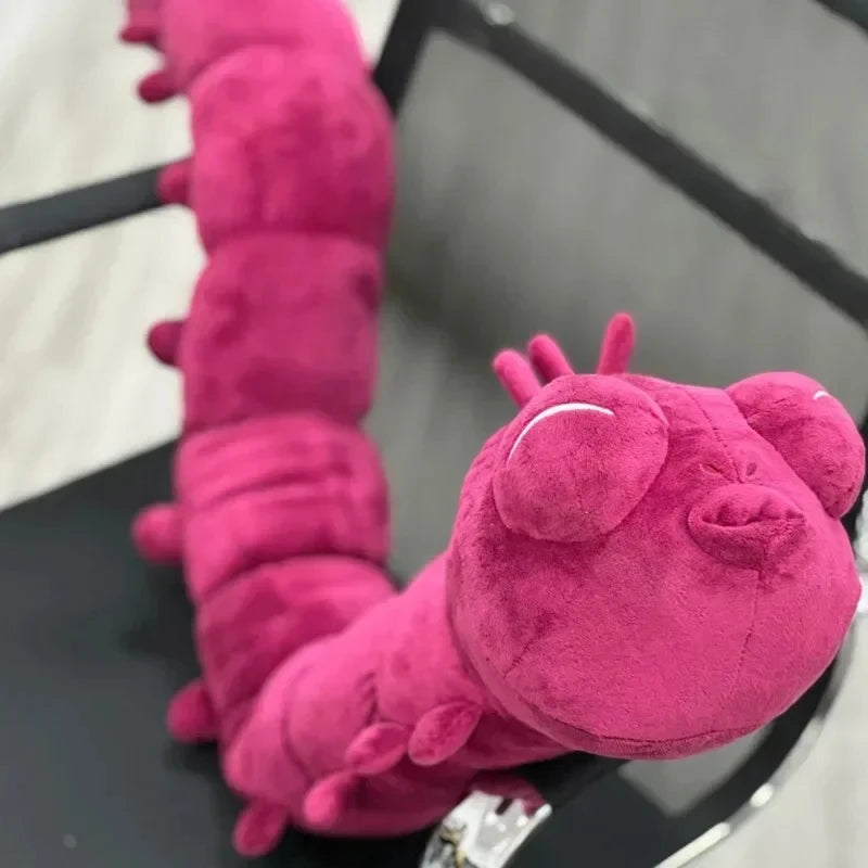 Peluche violette, tête et patte duveteuses, longues sections en peluche, couture visible.