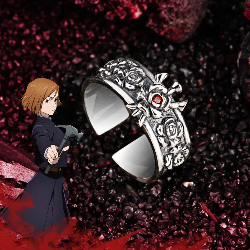 Bague argentée ornée de roses gravées et d’une pierre rouge centrale