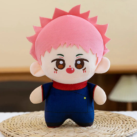Peluche Yuji Itadori Kawai à cheveux roses, grand yeux bruns, tenue bleu marine et col rouge.