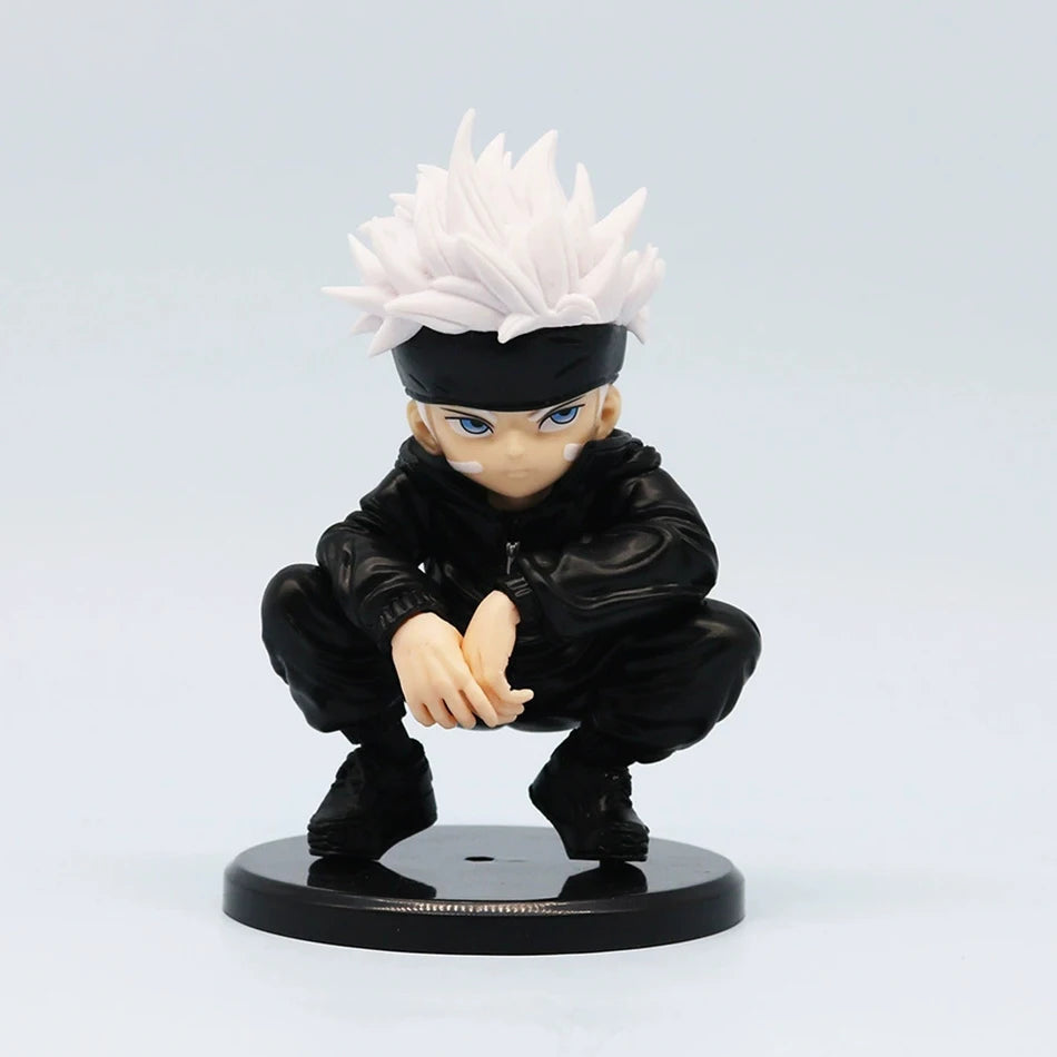 Figurine Chibi Gojo aux yeux bleus, cheveux blancs et veste noire, pose accroupie