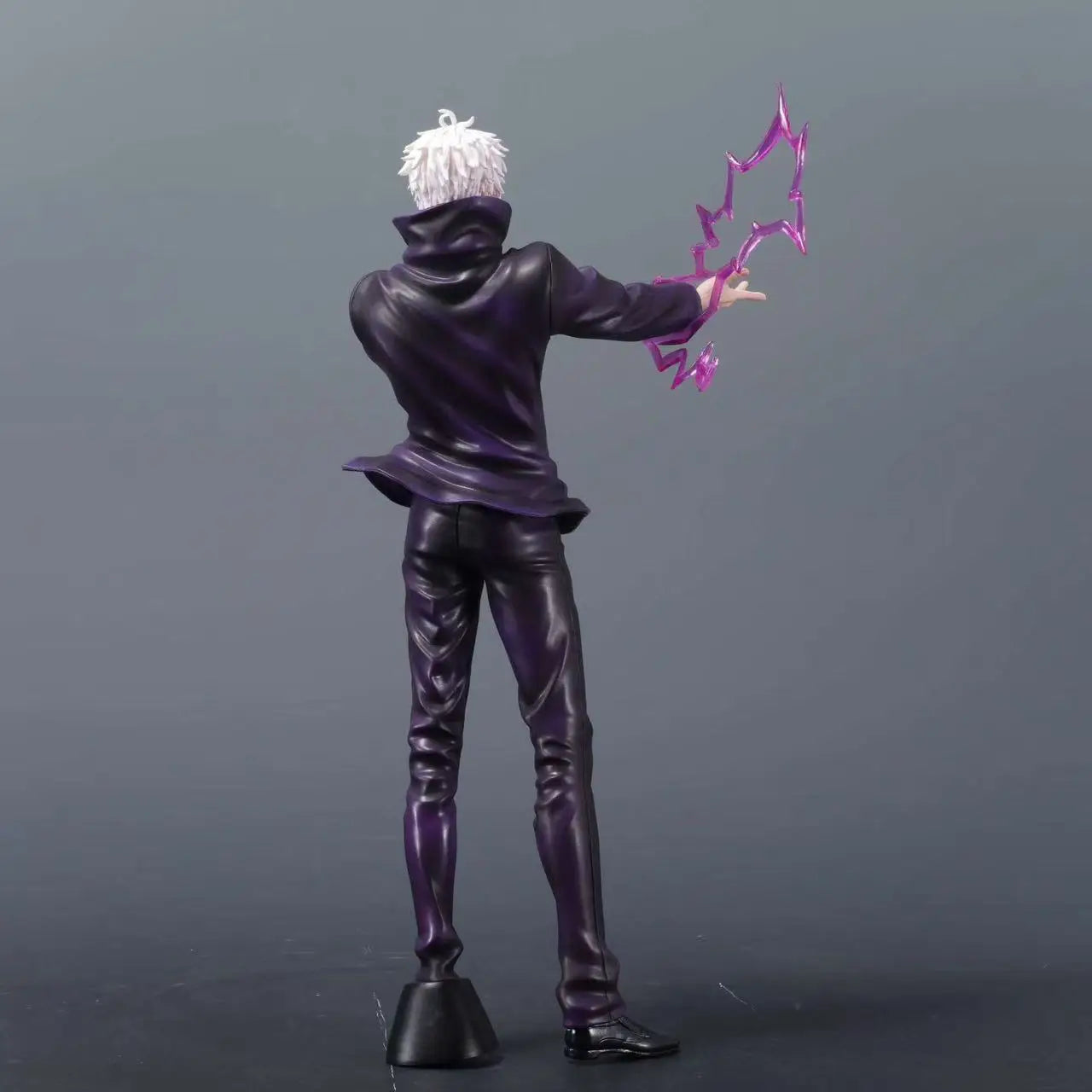 Figurine personnage en tenue sombre, cheveux blancs, énergie violette en forme d’éclats.