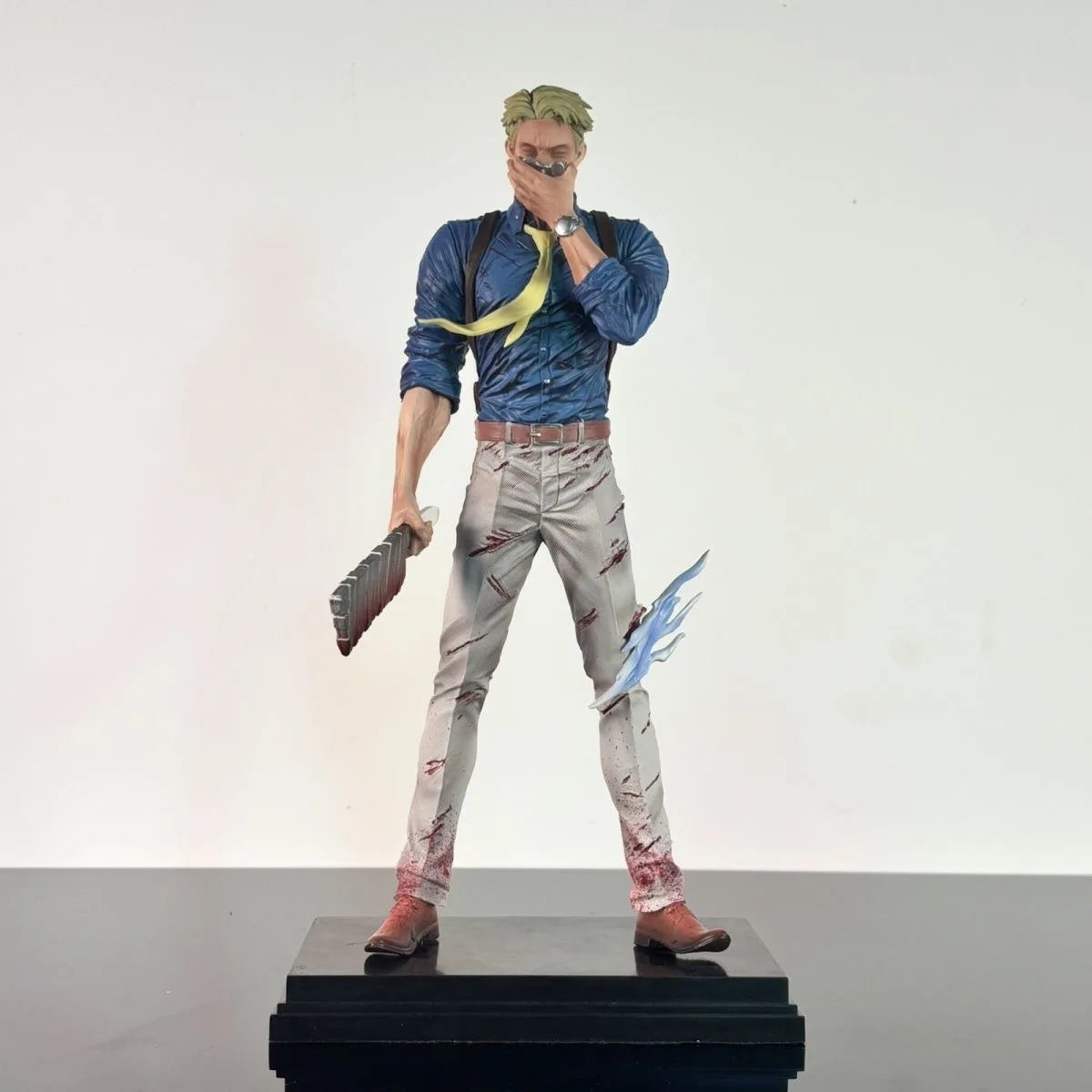 Figurine Jujutsu Kaisen Nanami Kento Trois Têtes 32cm : de Nanami Kento : veste bleue, pantalon clair, main sur le visage, arme et socle