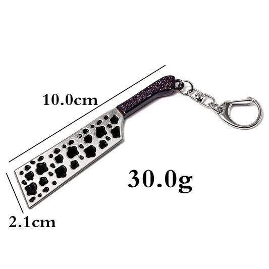 Porte-clés en forme d’arme, poignée violette et lame argentée à motifs noirs